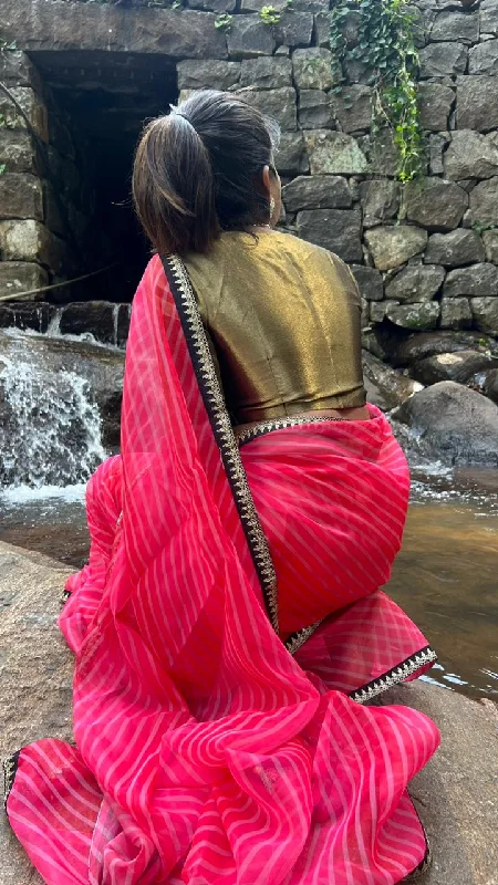 Pink stripped organza saree with black & gold blouse